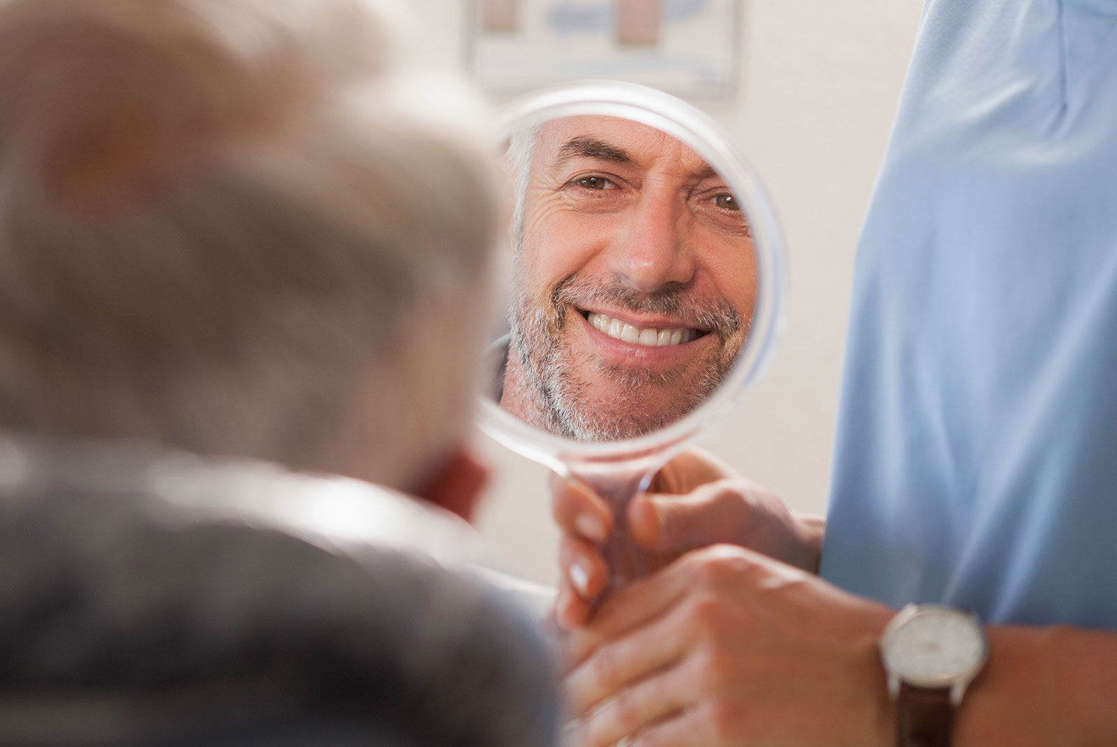 older male smiling brightly after their dental implant treatment