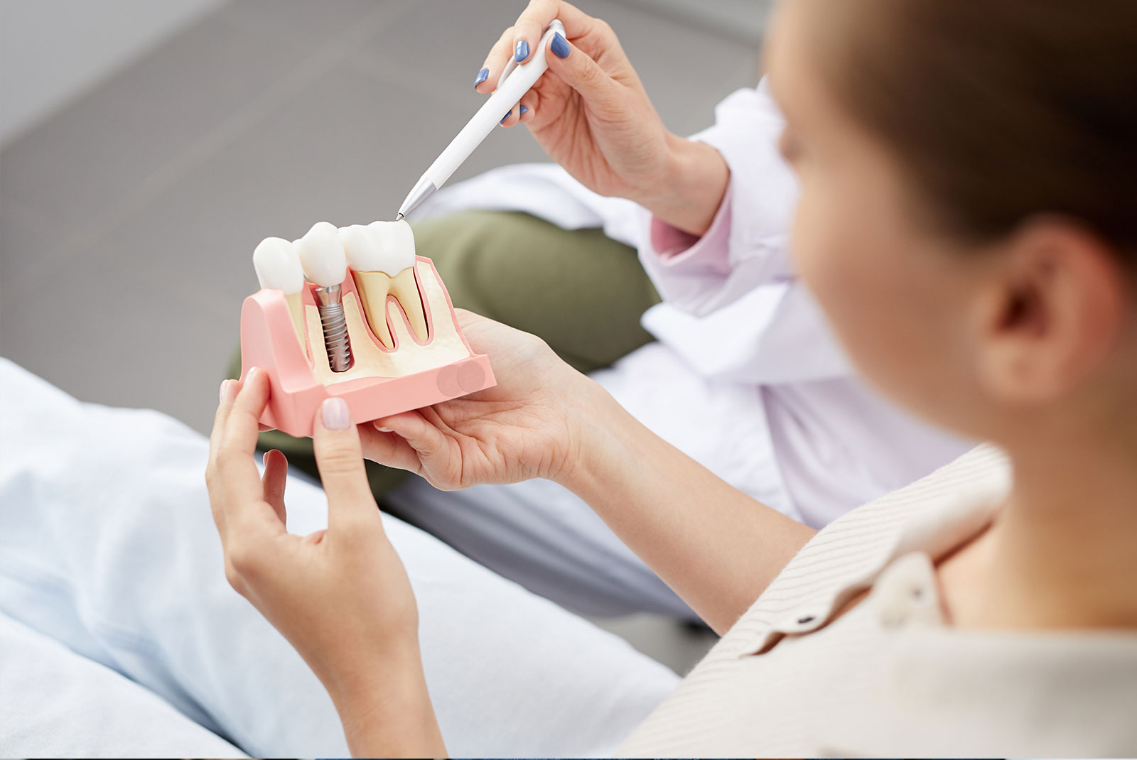 patient holding and examining full arch dental implant model