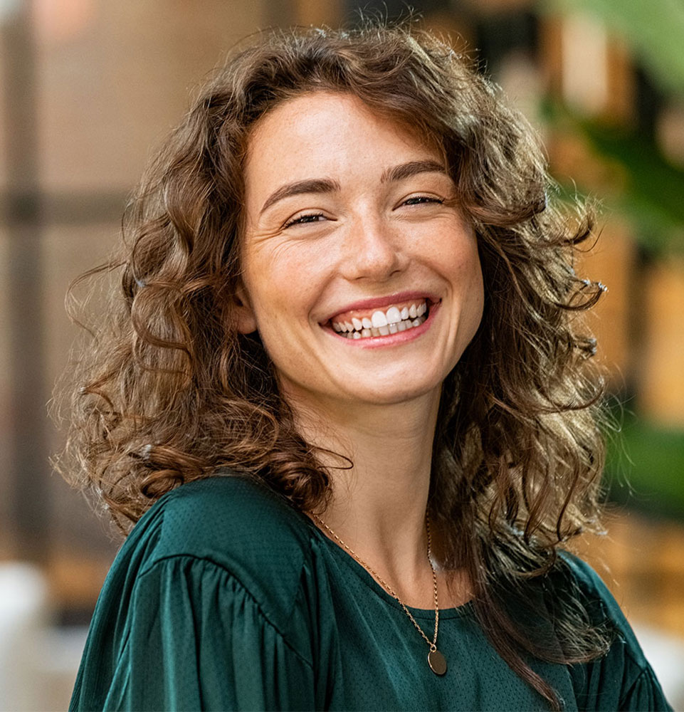 person smiling brightly while being outside in the sun