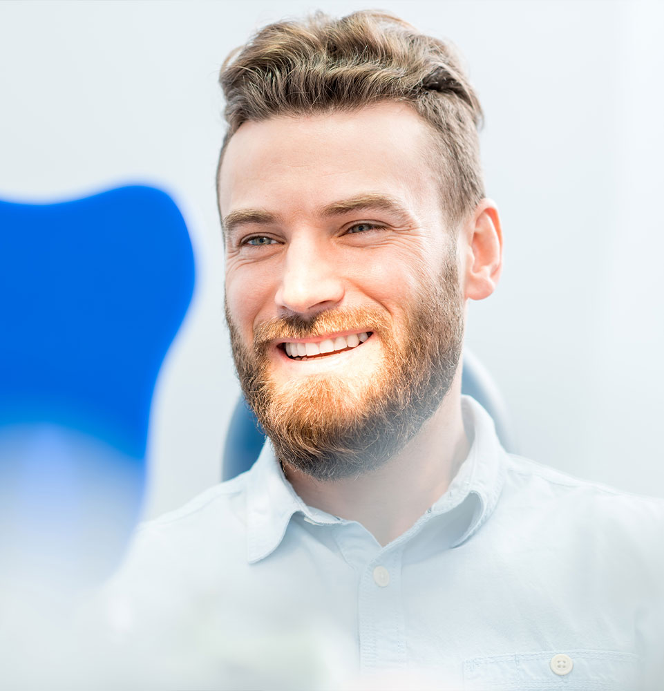older male patient smiling brightly after their dental implant procedure