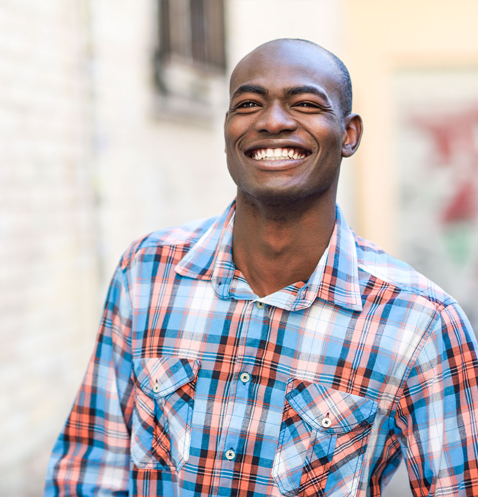 male smiling brightly while being outside during daytime